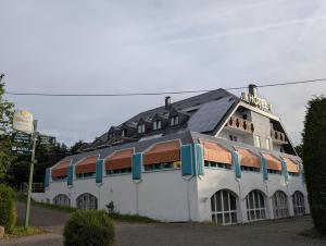 a large white building with a black roof at Zenners Landhotel in Newel