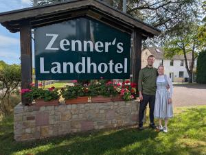 a man and woman standing in front of a sign at Zenners Landhotel in Newel