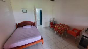 a bedroom with a bed and a table and chairs at Bellevue Studios in Mare Gaillard