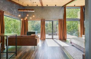 a bedroom with a bed and a desk and windows at Ramiau - su gamta in Kareivonys