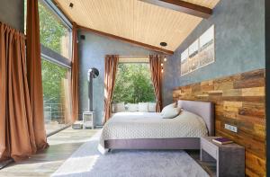 a bedroom with a bed and a large window at Ramiau - su gamta in Kareivonys