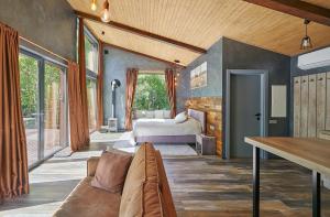 a bedroom with a bed and a couch in a room at Ramiau - su gamta in Kareivonys