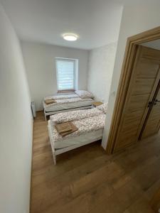 two beds in a room with a door open at Apartament JULIA in Głuszyca