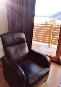 a black leather chair sitting in front of a window at Apartman MARLEA in Donovaly +56 photos