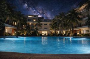 ein Schwimmbad vor einem Gebäude bei Nacht in der Unterkunft Oasis del Sol in Playa del Carmen