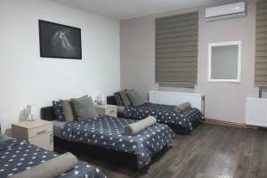 a living room with three beds and a couch at Alex Lodge in Zrenjanin