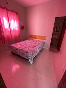 a bedroom with a bed in a pink room at Casa Temporada Trairi in Trairi +14 photos