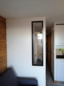 a mirror on the wall of a living room at Charming mountain studio in Mont-Saxonnex
