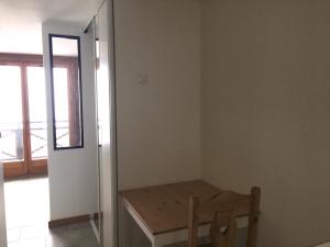 a room with a wooden table and a window at Charming mountain studio in Mont-Saxonnex