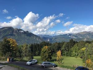 two cars parked in a parking lot with mountains in the background at Charming mountain studio in Mont-Saxonnex