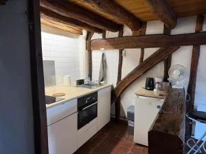 a kitchen with white cabinets and a stove top oven at historique in Clamecy +2 photos