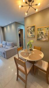a living room with a table and chairs and a couch at Apartamento Exec Premium Queen Bed Centro-Taubate in Taubaté