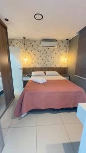 a bedroom with a large bed with a red blanket at Apartamento Exec Premium Queen Bed Centro-Taubate in Taubaté