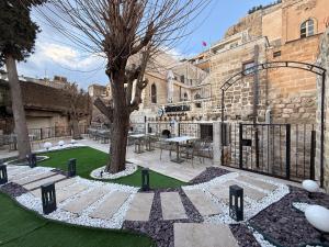 a courtyard with a tree and a fence at Sümerler Konağı in Mardin