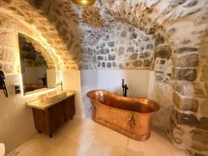 a bathroom with a copper tub and a sink at Sümerler Konağı in Mardin +102 photos