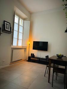 a living room with a table and a flat screen tv at Casa Politi in Parma