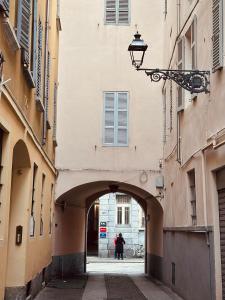 an alleyway between two buildings with a person walking through it at Casa Politi in Parma