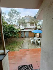 a patio with a table and a blue umbrella at Casa I Limoni in Viareggio
