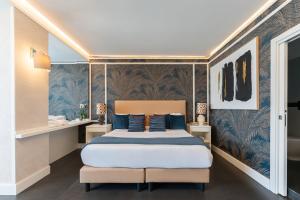 a bedroom with a large bed with blue pillows at Hotel Il Gabbiano in Bacoli +148 photos