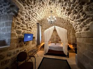 a bedroom with a bed in a stone wall at Sümerler Konağı in Mardin