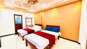 a bedroom with two beds and a ceiling at Asmi Villa in Jaffna