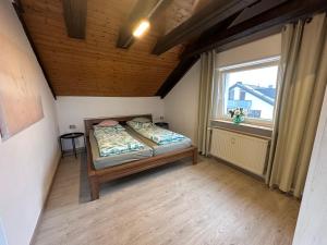 a bedroom with a bed in a room with a window at Ferienwohnung Löchgau in Löchgau