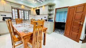 a kitchen with a wooden table and some chairs at Asmi Villa in Jaffna