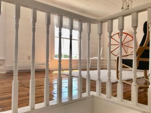 a staircase in a house with white railings at The Old Salt Box Co. - Evelyn's Place in Herring Neck