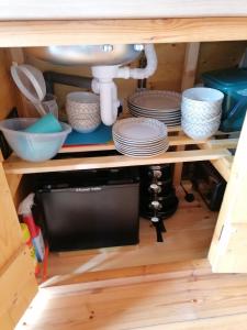 a kitchen cabinet with plates and a sink at Castle View Glamping - 2 Cefn in Llandrindod Wells +10 photos