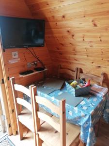 a room with a table with chairs and a television at Castle View Glamping - 2 Cefn in Llandrindod Wells