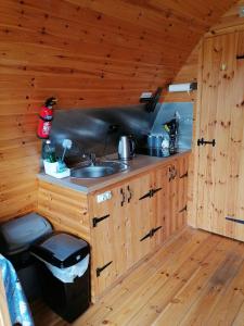 a kitchen with wooden cabinets and a sink in a cabin at Castle View Glamping - 2 Cefn in Llandrindod Wells