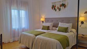 ein Hotelzimmer mit zwei Betten mit grün-weißer Bettwäsche in der Unterkunft Las Perdices in Válor