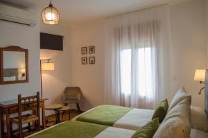 ein Schlafzimmer mit zwei Betten, einem Tisch und einem Fenster in der Unterkunft Las Perdices in Válor + 38 Fotos
