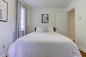 a white bed in a white bedroom with a window at Jolly Jefferson Ave Walk to the Best of Midtown in Memphis