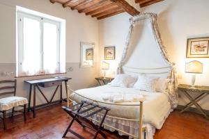 a bedroom with a canopy bed and a desk at Il Nido Di Anna in San Gimignano
