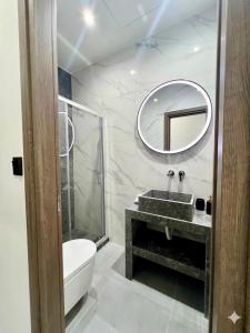 a bathroom with a sink and a toilet and a mirror at Kilada Luxury Apartment 1 in Kilada +22 photos