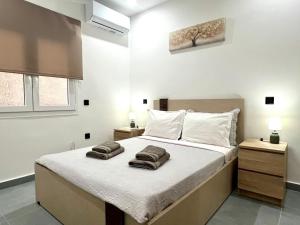 a bedroom with a large bed with two towels on it at Kilada Luxury Apartment 1 in Kilada