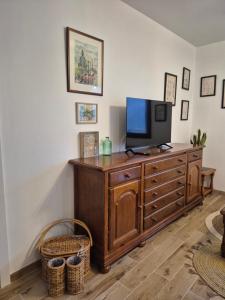 a living room with a television on a wooden dresser at Casa La Candela in Montemayor del Río +62 photos