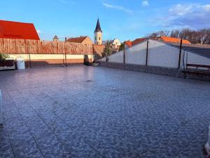 a stone courtyard with a fence and a building at Ubytovna u Maiky in Libochovice