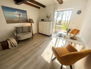 a living room with a table and a chair at Hof Steinhütten in Westerhever