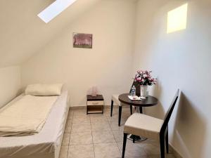 a small room with a bed and a table with flowers at Ubytovna u Maiky in Libochovice