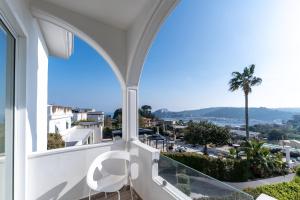 a balcony with a view of the ocean and palm tree at Hotel Il Gabbiano in Bacoli