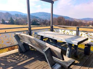 a wooden bench sitting on top of a wooden deck at KORBIELOVKA domek z sauną in Korbielów +78 photos