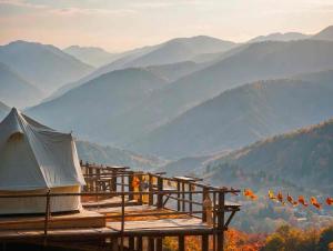 a tent on a deck with mountains in the background at Infinite horizon nan in Ban San Khet Yao
