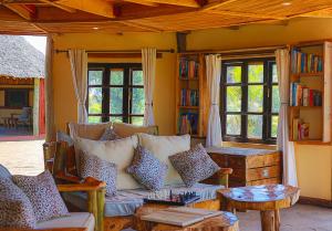 a living room with a couch and some windows at Amboseli Discovery Camp in Amboseli