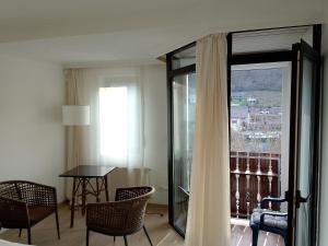 a room with a balcony with a table and chairs at Hotel Balduin - Natur & Flussblick in Balduinstein