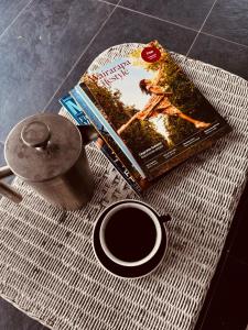 a book and a cup of coffee on a table at Pinegrove Cottage - Greytown Getaway in Woodside