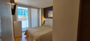 a small bedroom with a bed and a window at Avenida Diagonal - Próximo a Sagrada Familia y parking gratis - Angeles Terraza in Barcelona