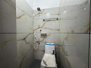 a bathroom with a toilet and a marble wall at Cozstel in Kozhikode