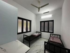 a room with two beds and two windows at Cozstel in Kozhikode